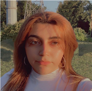 A white female in a blue blouse with a green background